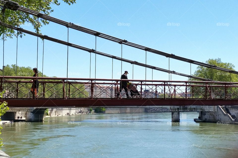 People passing on the bridge in Lyon, France.