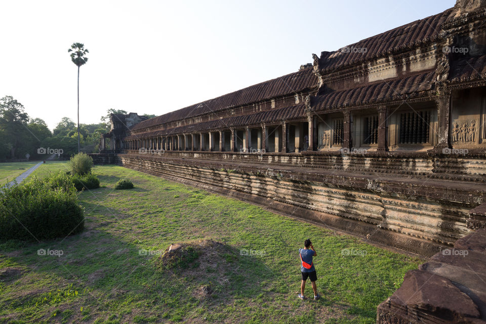 Man tourist taking a photo of the Ankor Wat temple in Siem Reap Cambodia 