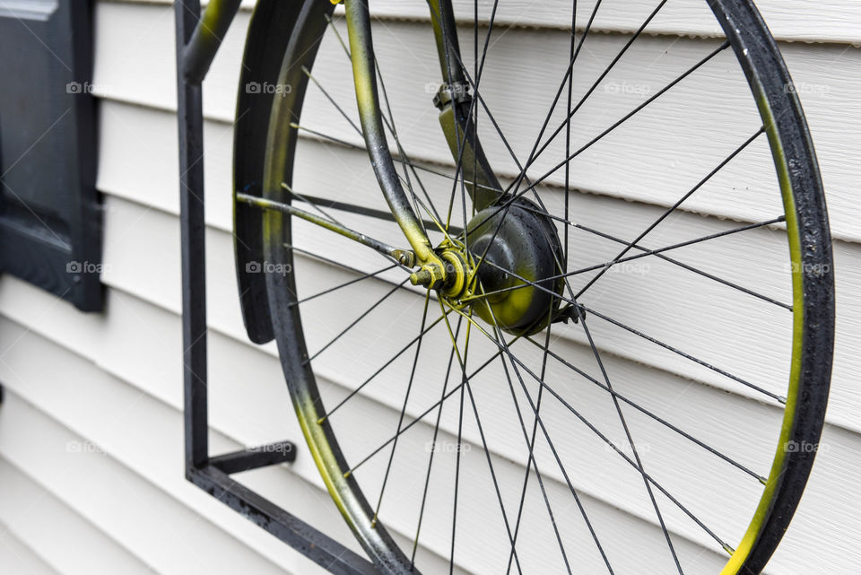 Vintage bike wheel hung from the siding of a building