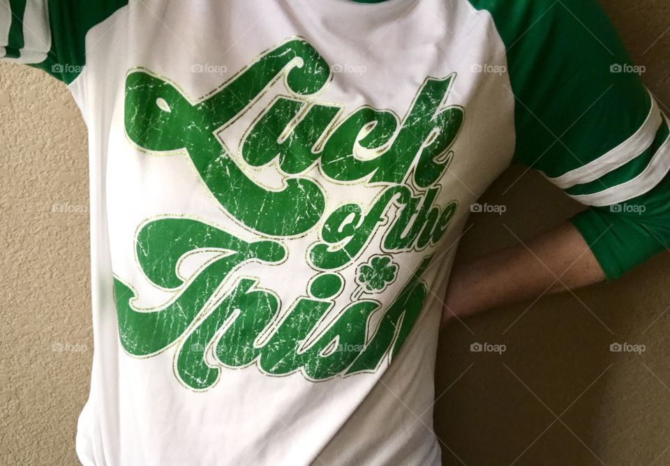 A girl wearing a St. Patrick’s Day luck of the Irish white and green T-shirt in celebration of St Patrick’s Day. USA, America
