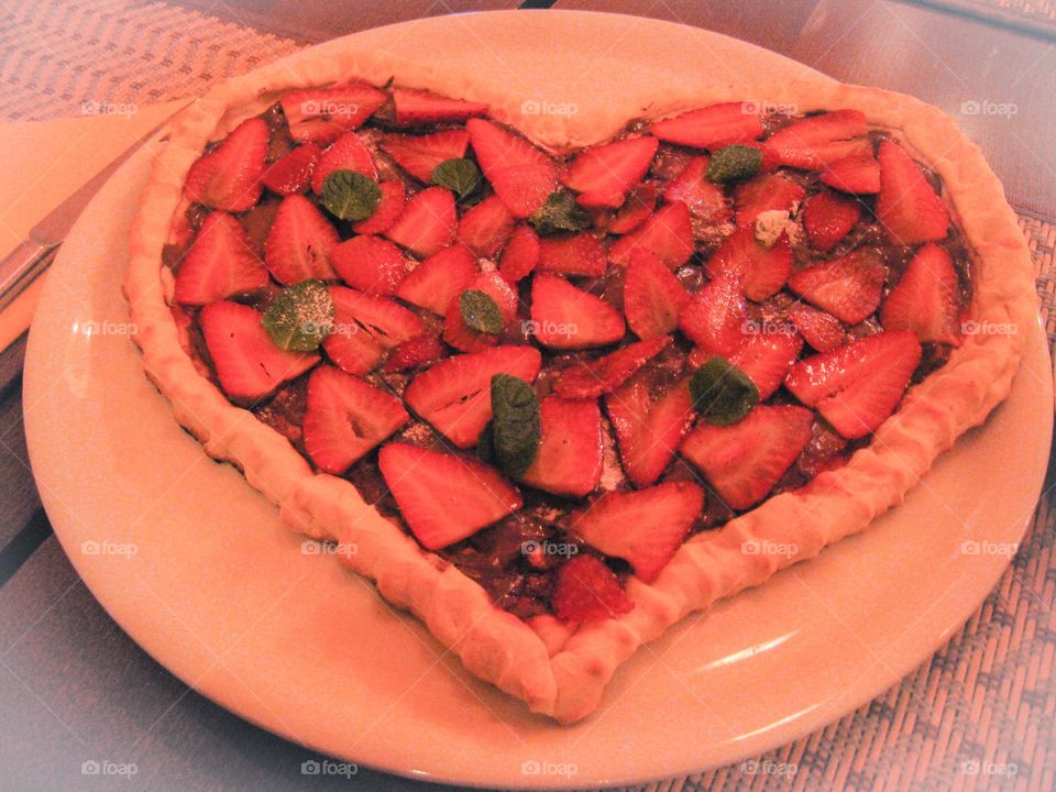 St Valentines heart-shaped sweet pizza, strawberries, Nutella and mint leaves