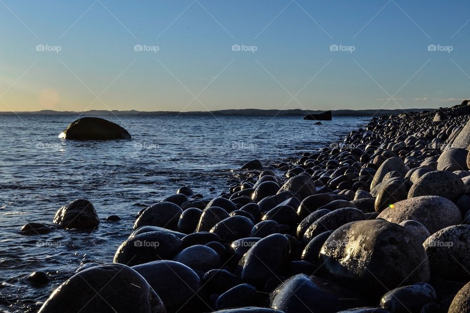 From Mølen. A Beach of round Stones as a ra out in the Sea. 
