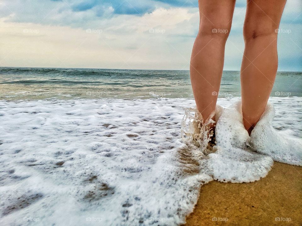 Female legs standing in the Atlantic ocean