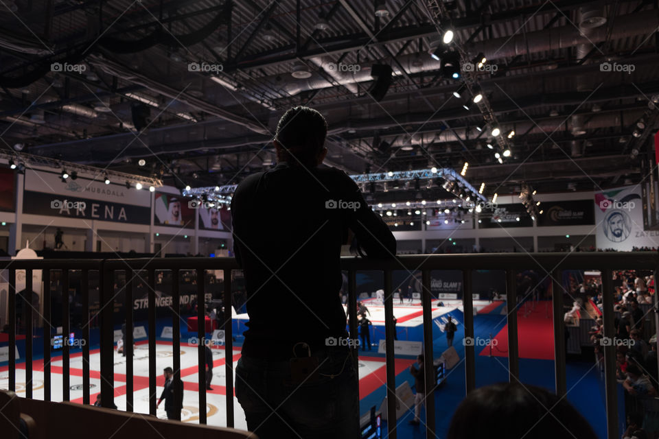 Silhouette of a woman spectator watching Judi in Arena
