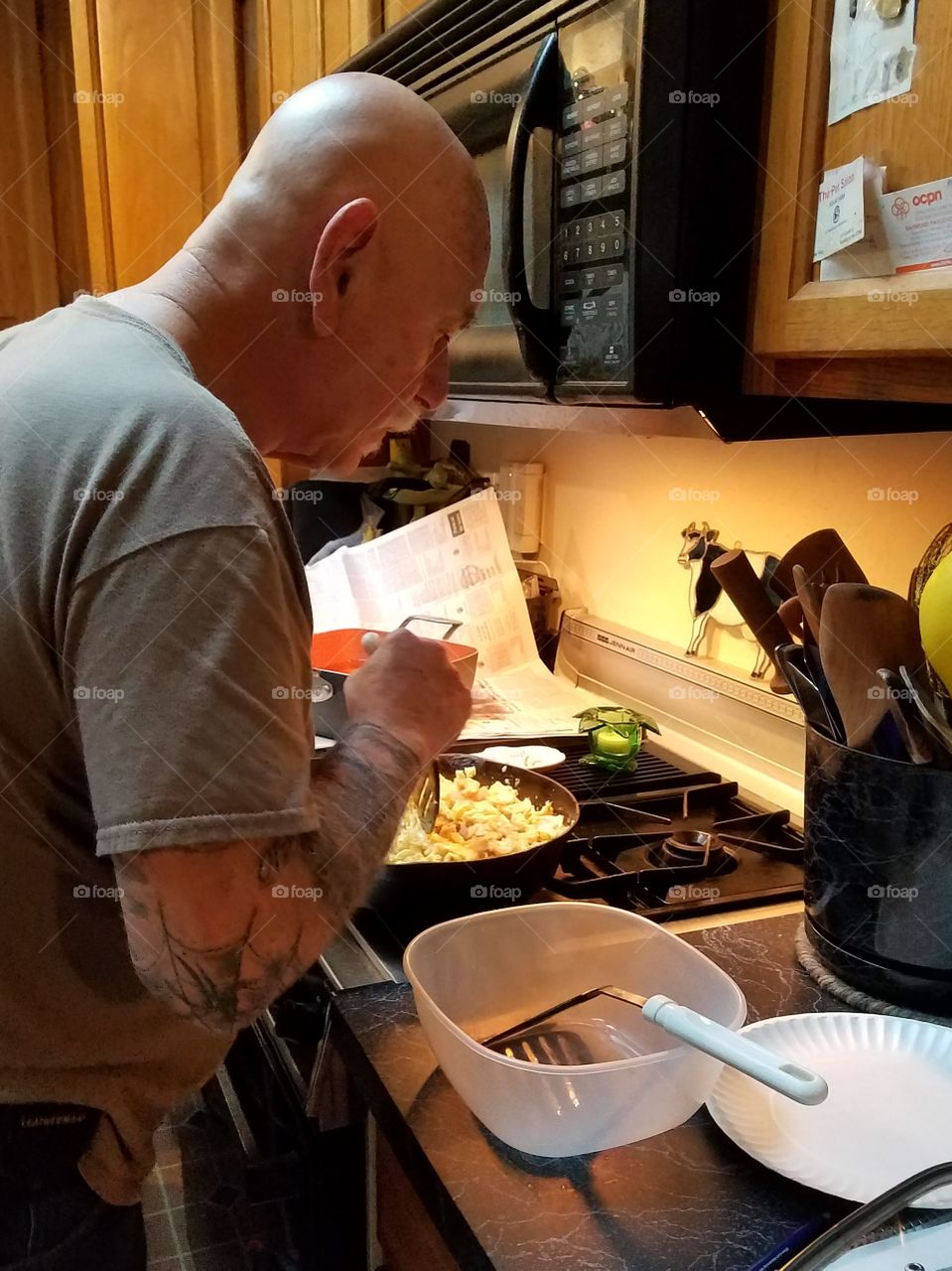 Man cooking over pans at stove.