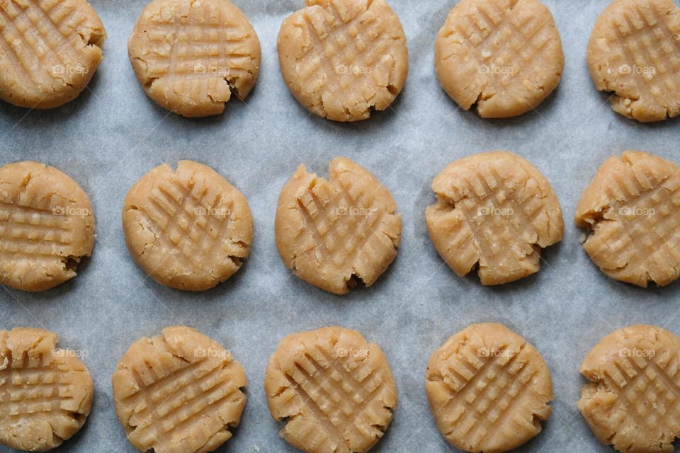 Flat lay with raw American peanut butter cookies on a baking sheet lined with baking paper