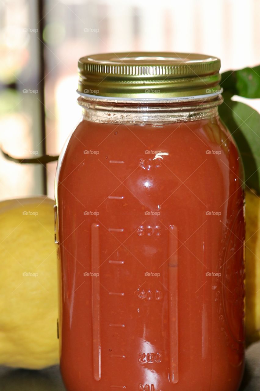 View closeup freshly made jar of quince fruit sauce in country kitchen 