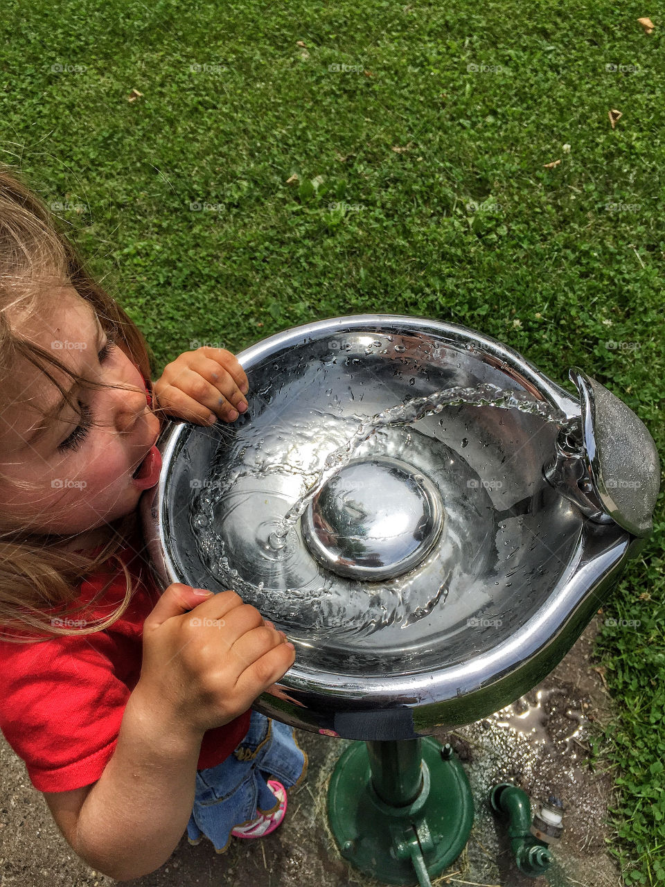 Girl drinking water from water fountain
