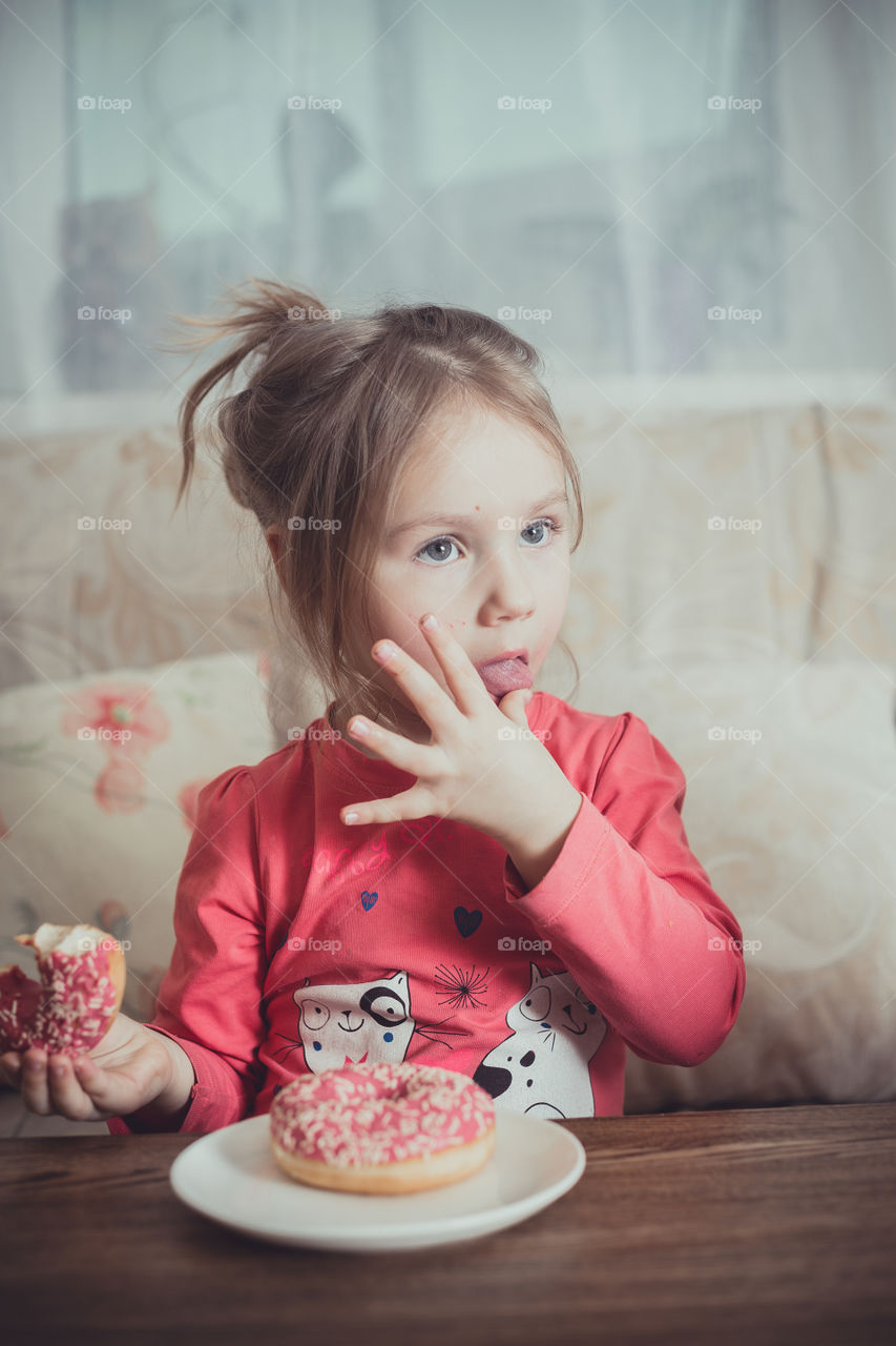 Little girl eating donuts 