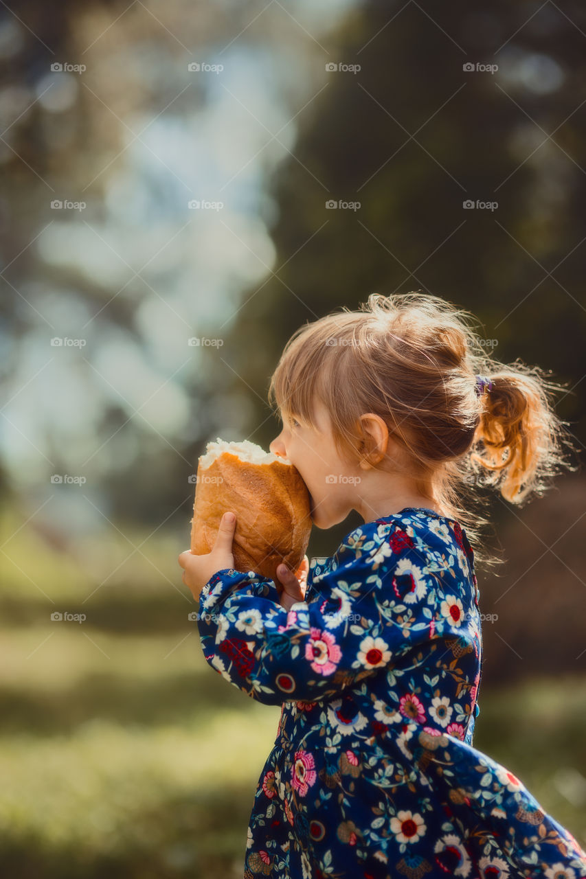 Cute little girl eating bread