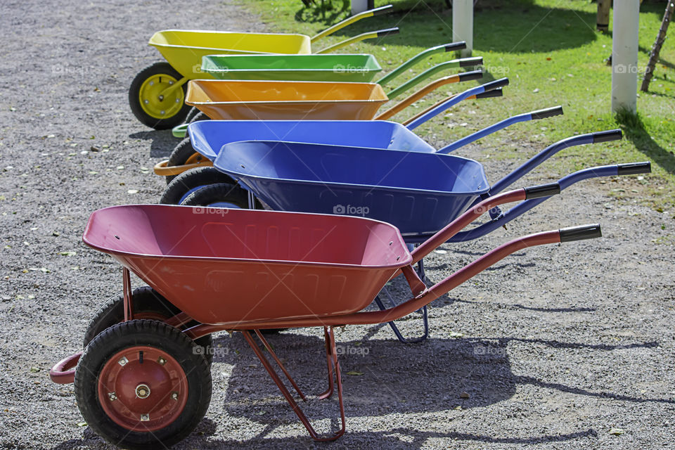 wheelbarrow carts colorful material on the floor.