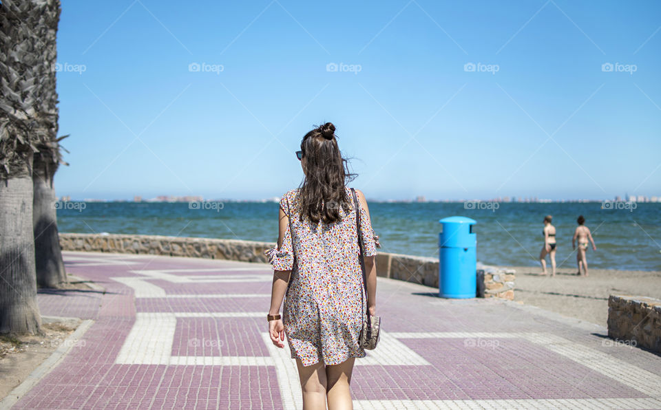 Young girl walking along the beach on summer season