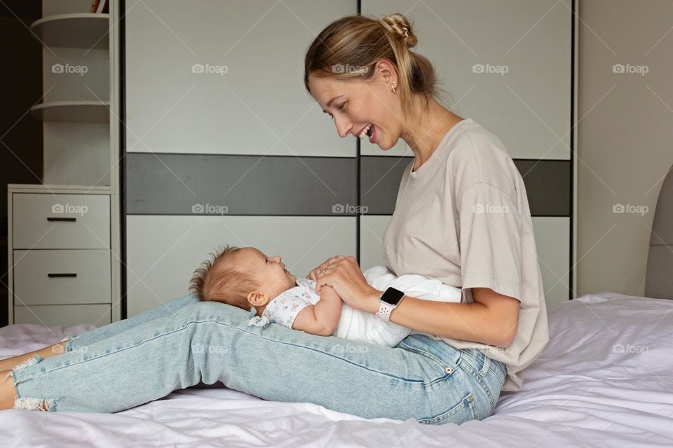 Mother playing with newborn baby 