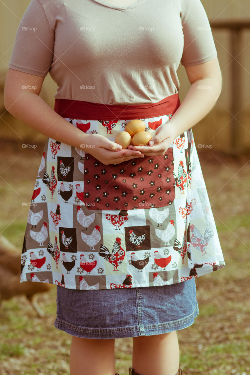 Woman with apron holding eggs