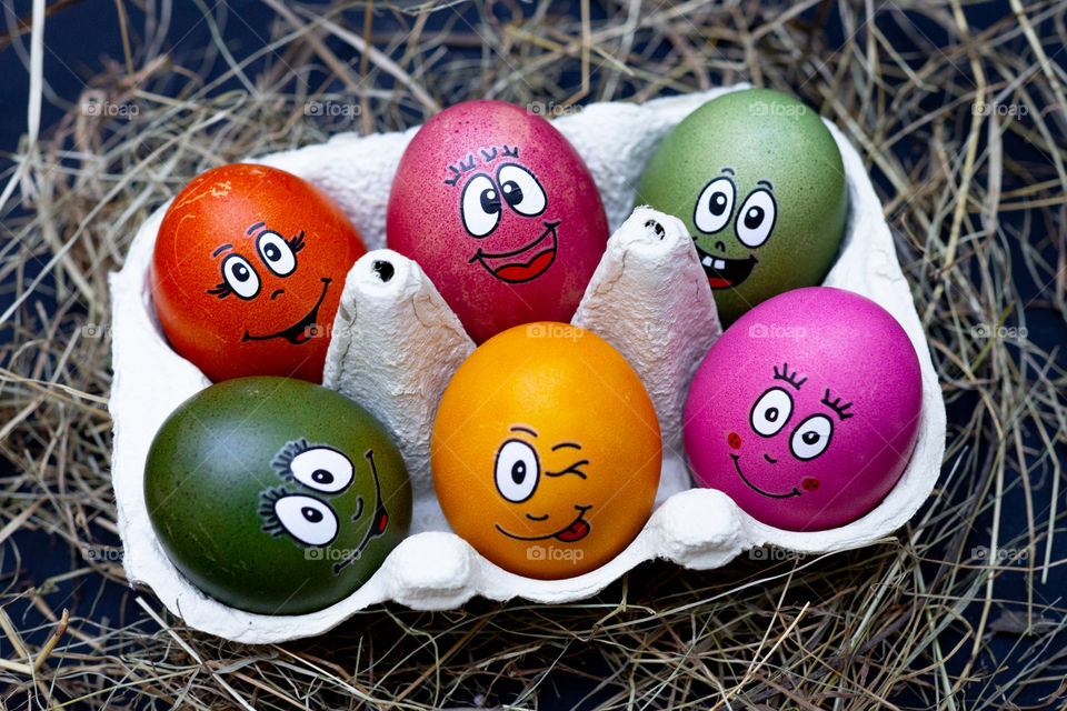 six colorful easter eggs with faces