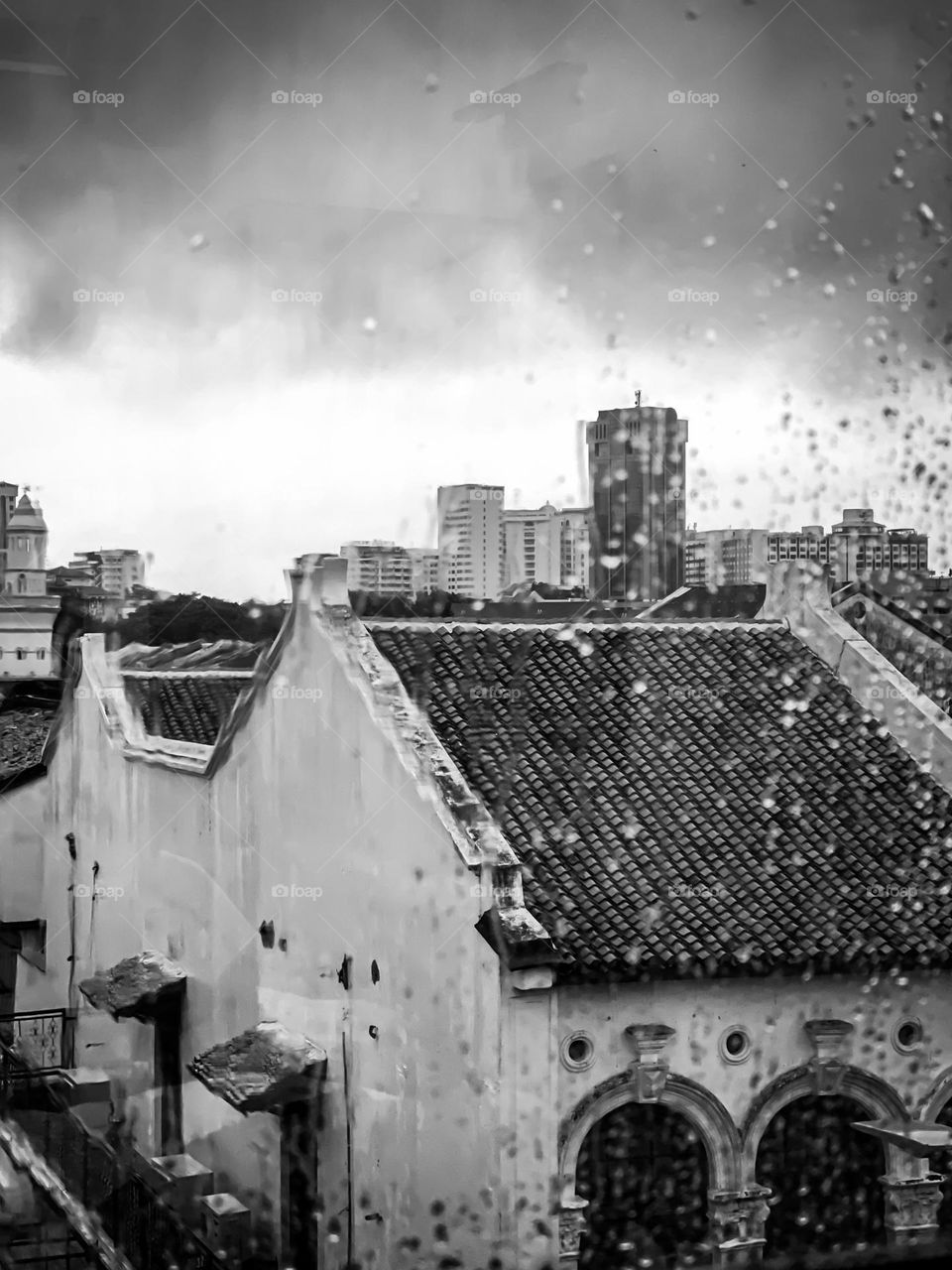 Old buildings taken from a wet window with water droplets 