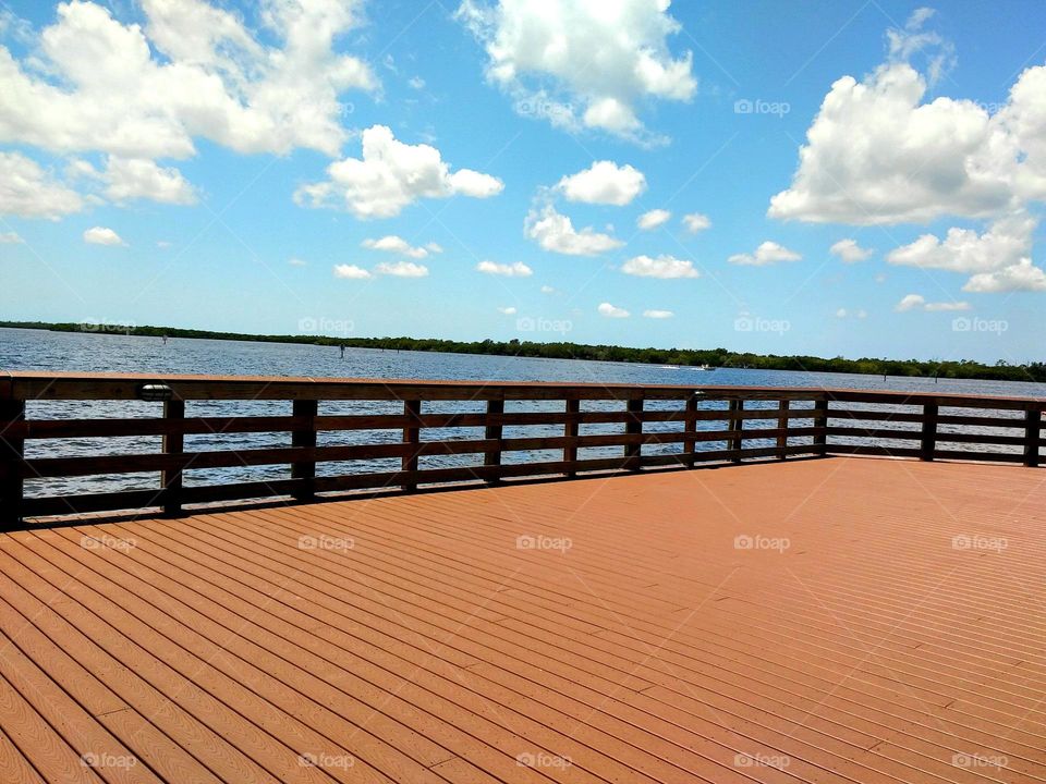 Walking across a big wooden deck on the harbor off the Gulf Coast of Florida.