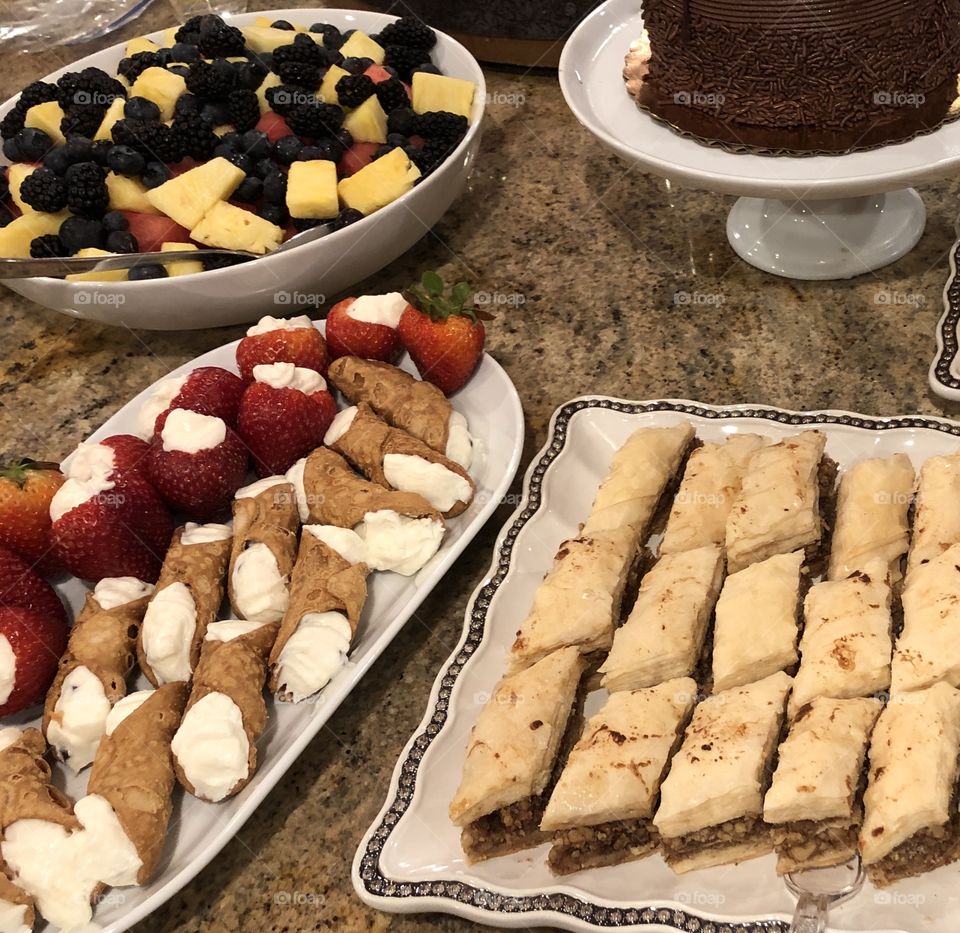 Baklava, cannoli, chocolate cake and fruit dessert table