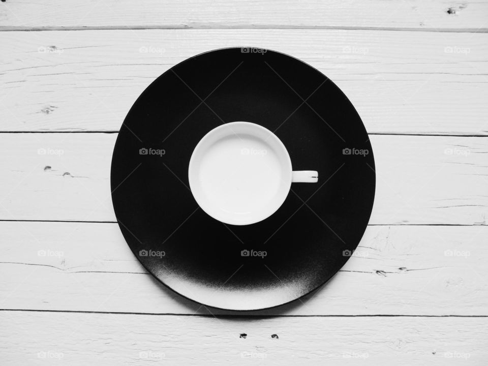 Cup and black plate on the wooden table