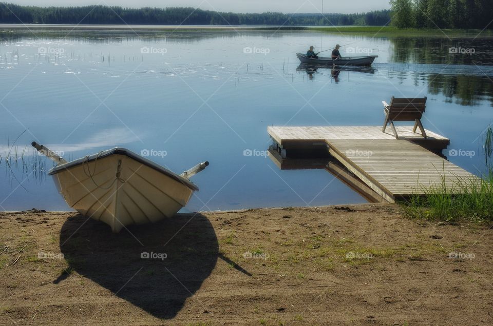 Gone fishing. . I've been staying by the lake shore when I saw this boat where a boy and his dad went wishing. My camera was with me. 