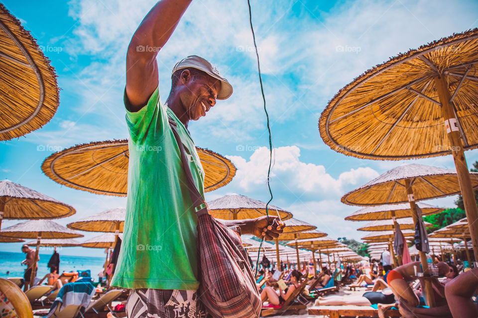 Man making bracelets on the beach