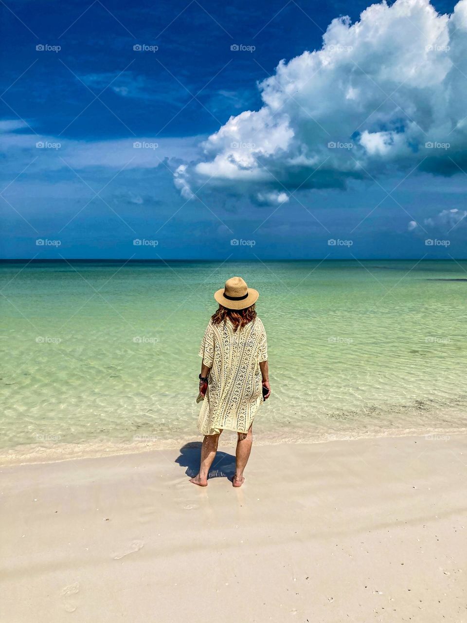 A beautiful woman admiring the amazing colours on Holbox Beach.