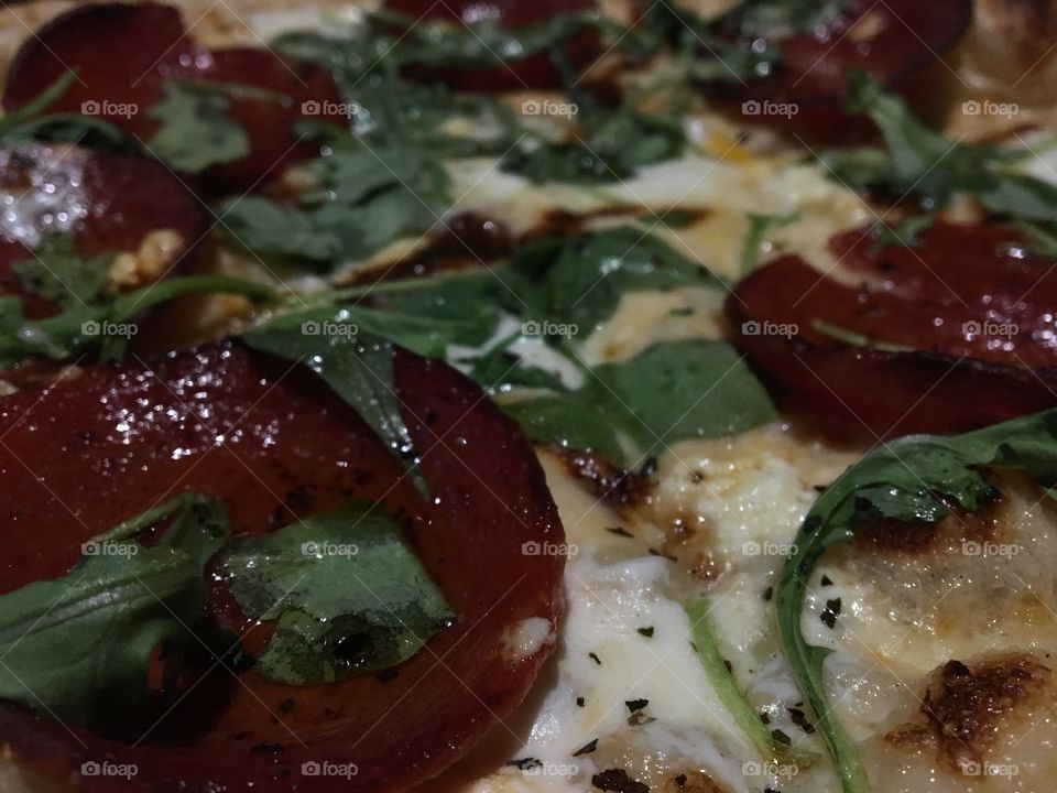 Delicious brick oven pizza with a creamy white sauce, pepperoni, garlic and fresh arugula- the perfect classy combination 