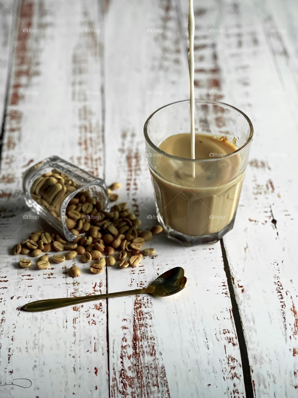 Coffee and milk in a glass. Coffee beans on the side