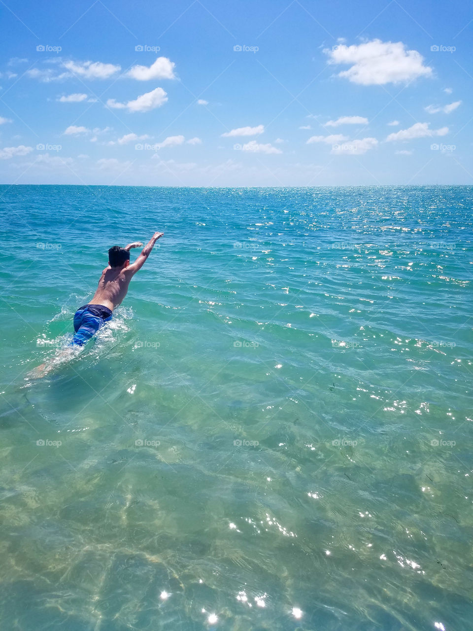Leaping forward with the exuberance of youth into the ocean