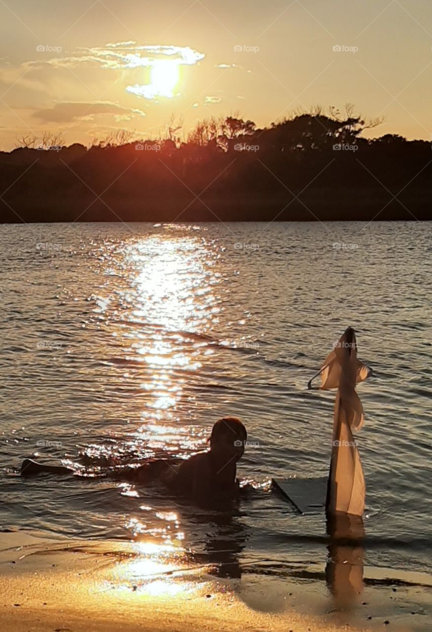 sailing his raft in the gold dusk