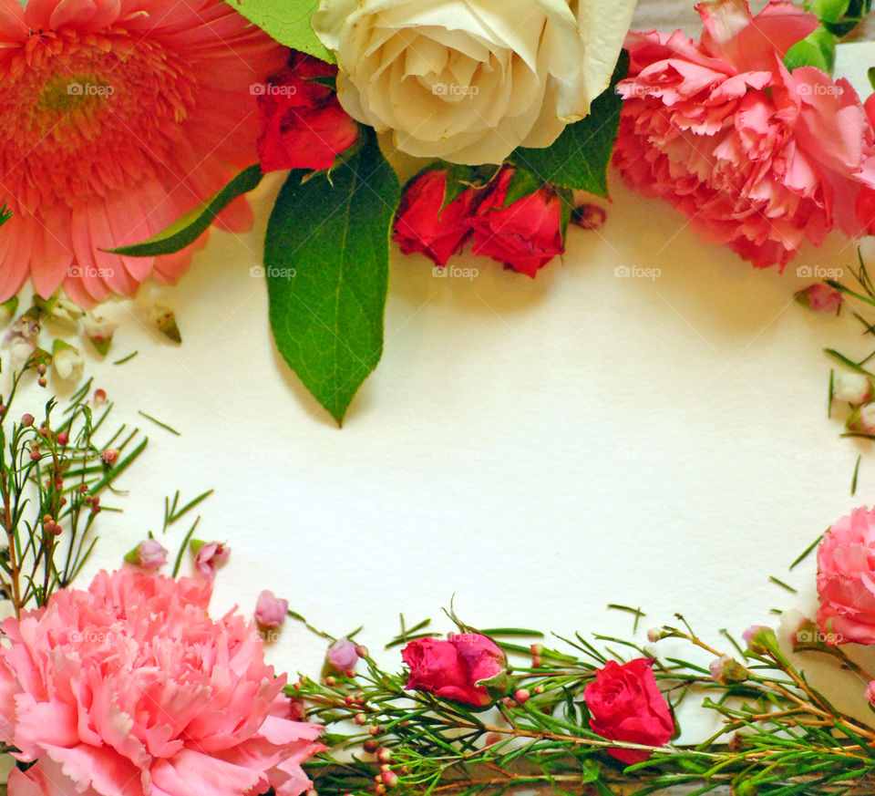 Spring, flowers, floral border, flower border, flat lay, white paper, wooden background, pink flowers and leaves, carnations, square orientation