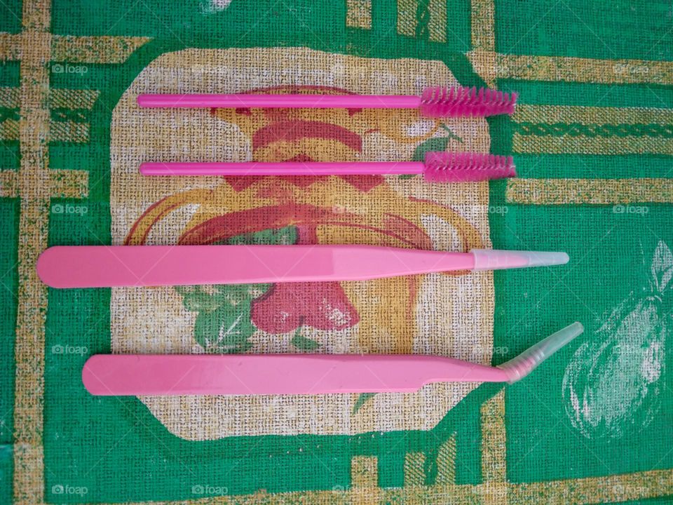 pink mascara brush and tweezers