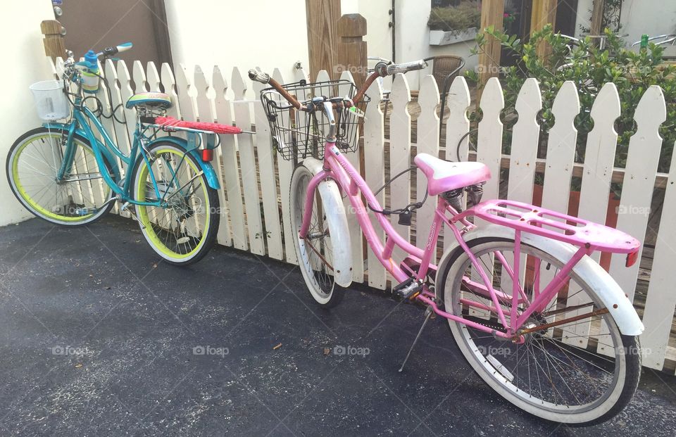 Take a load off. Bikes parked next to a white picket fence