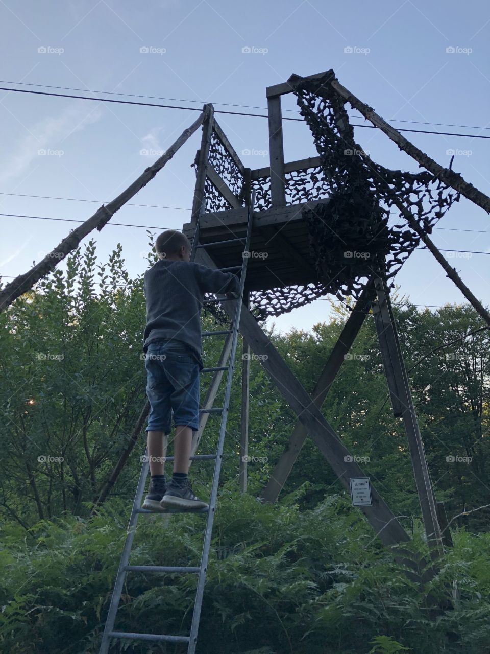 boy climbs hunting tower