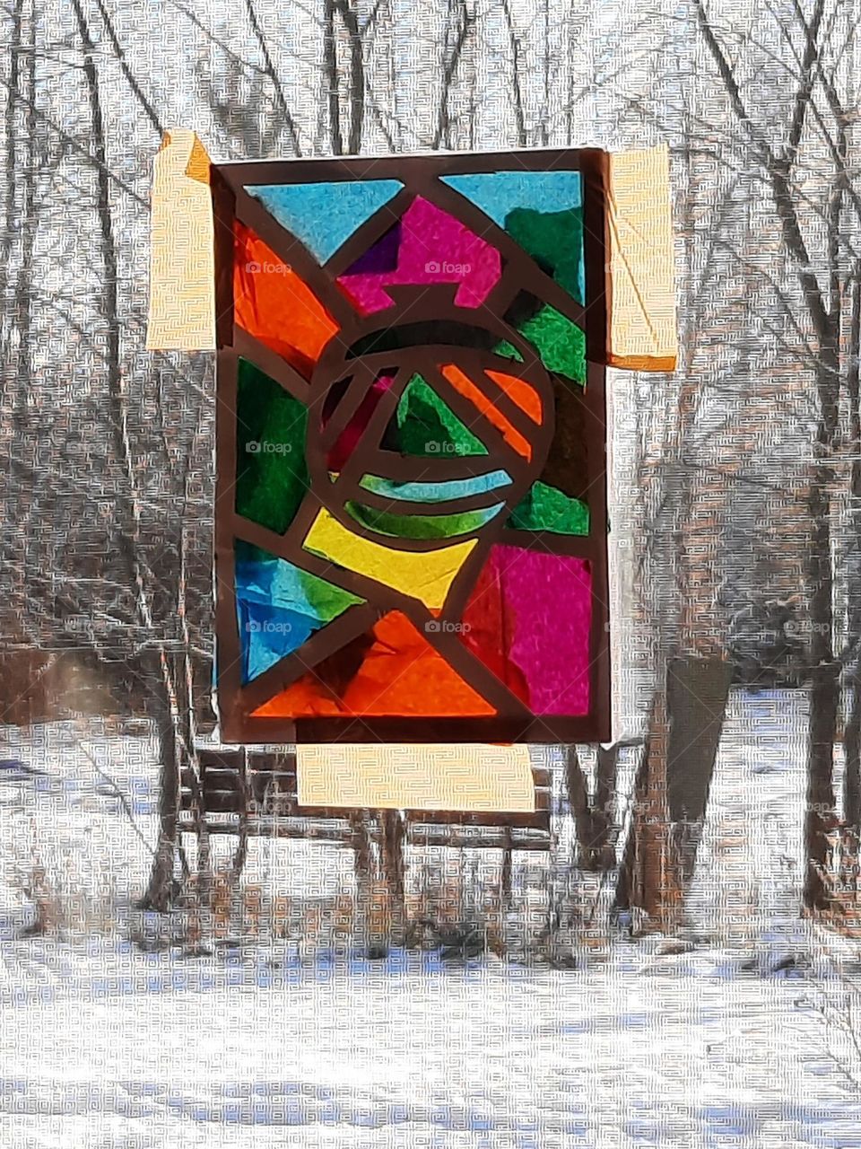 child's stained glass art against winter landscape