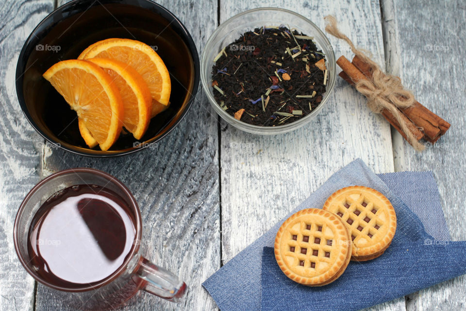 Tea tradition, tea, cup, mug, hot drink, cinnamon, cookies, napkin, jeans, denim napkin, fruit tea, flower tea, citrus, orange, lemon, rose petals, cookies, chocolate cookies, vanilla, vanilla sticks