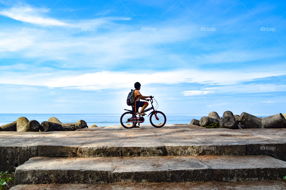 boy with bicycle by the beach