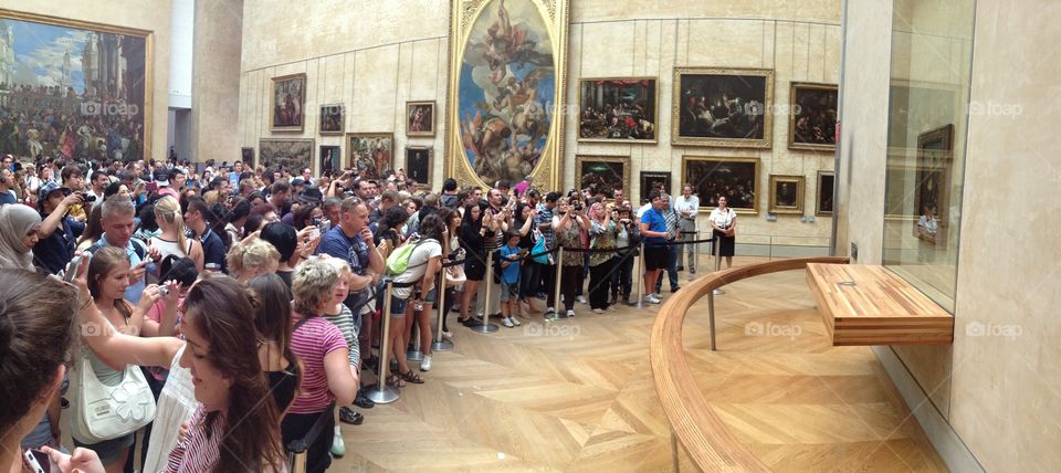 Crowds swarming inside the Louvre in Paris, all trying to get a glimpse of The Mona Lisa