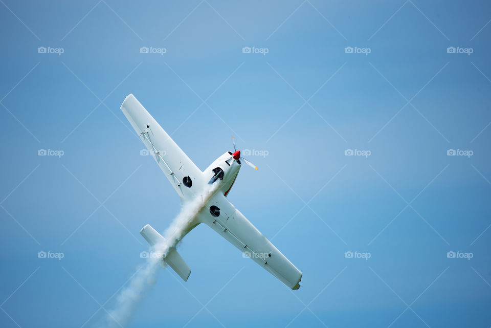 Small airplane flying on sky background