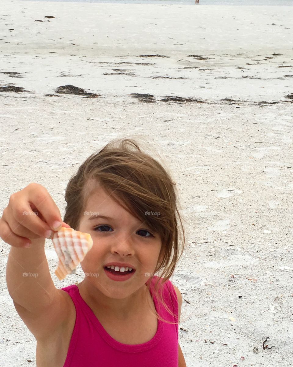 Girl holding sea shell in hand