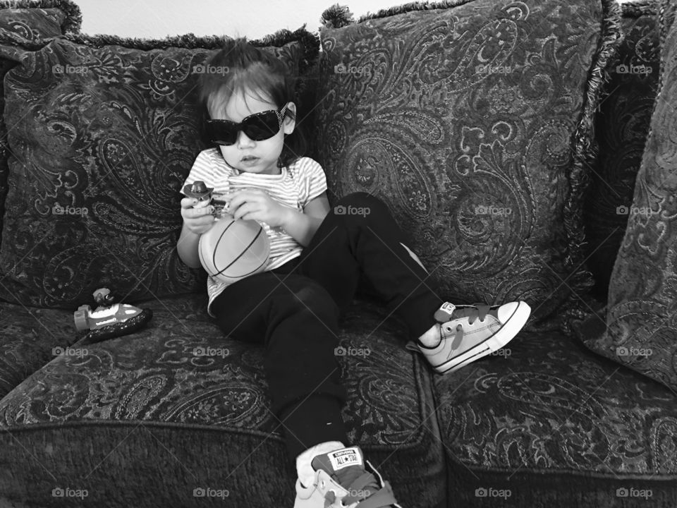 Girl sitting on sofa playing with toys