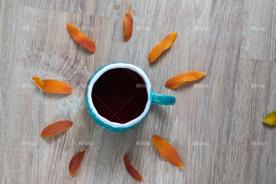 A cup of tea with autumn leaves on a background 