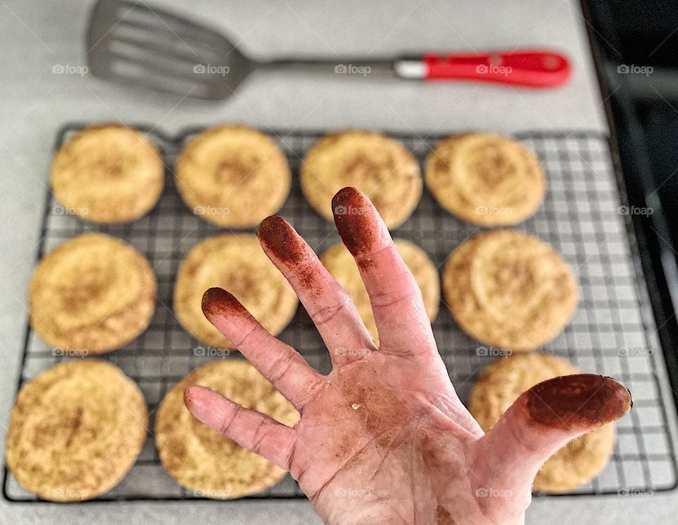 Dirty hands, woman’s hands covered in cinnamon, making snickerdoodles by hand, rolling cookies in cinnamon, making homemade cookies 