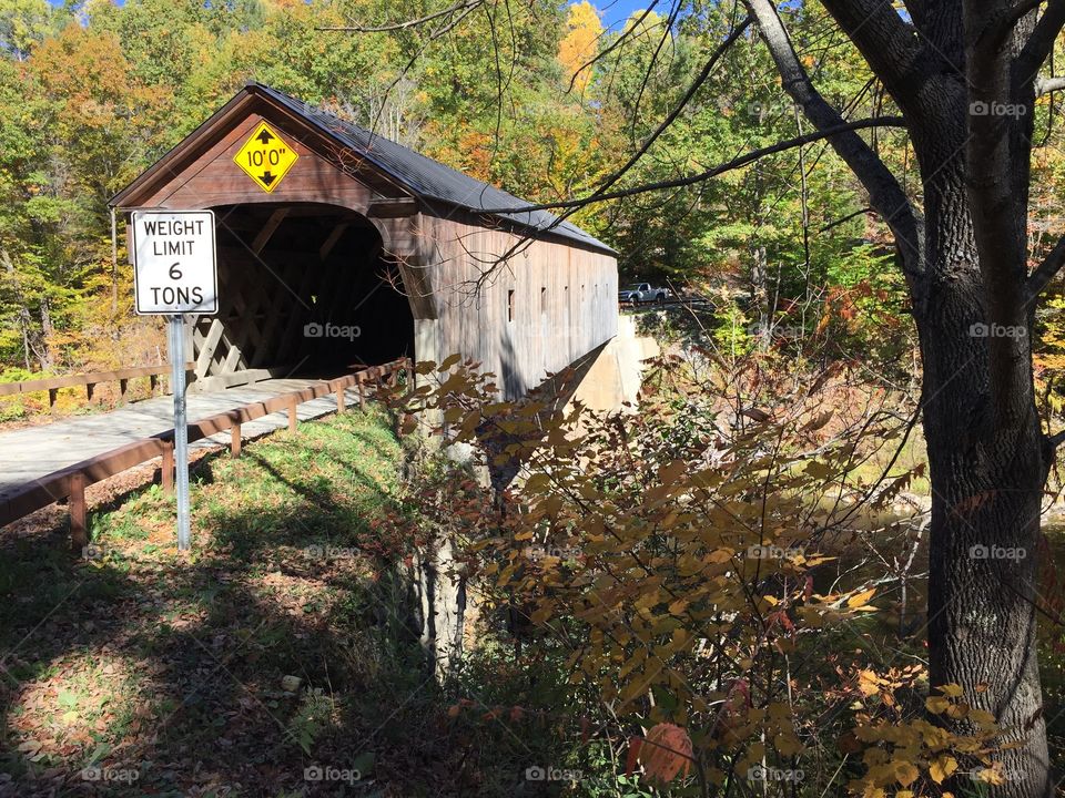 A covered bridge in Vermont during fall foliage season. 