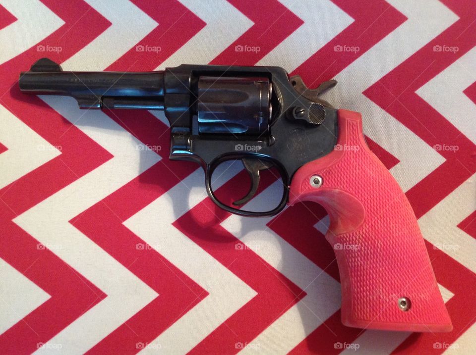 Pink Protector. Gun with pink grips on pink and white chevron background