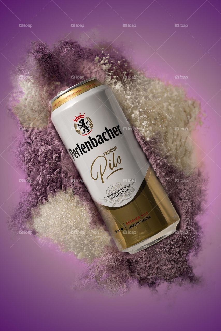 A can of beer in a bright explosion. Lilac and gold