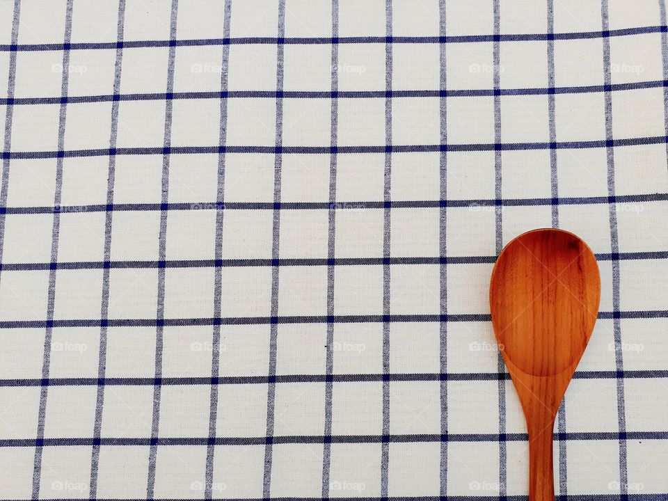 a wooden ladle on bluey-white napery