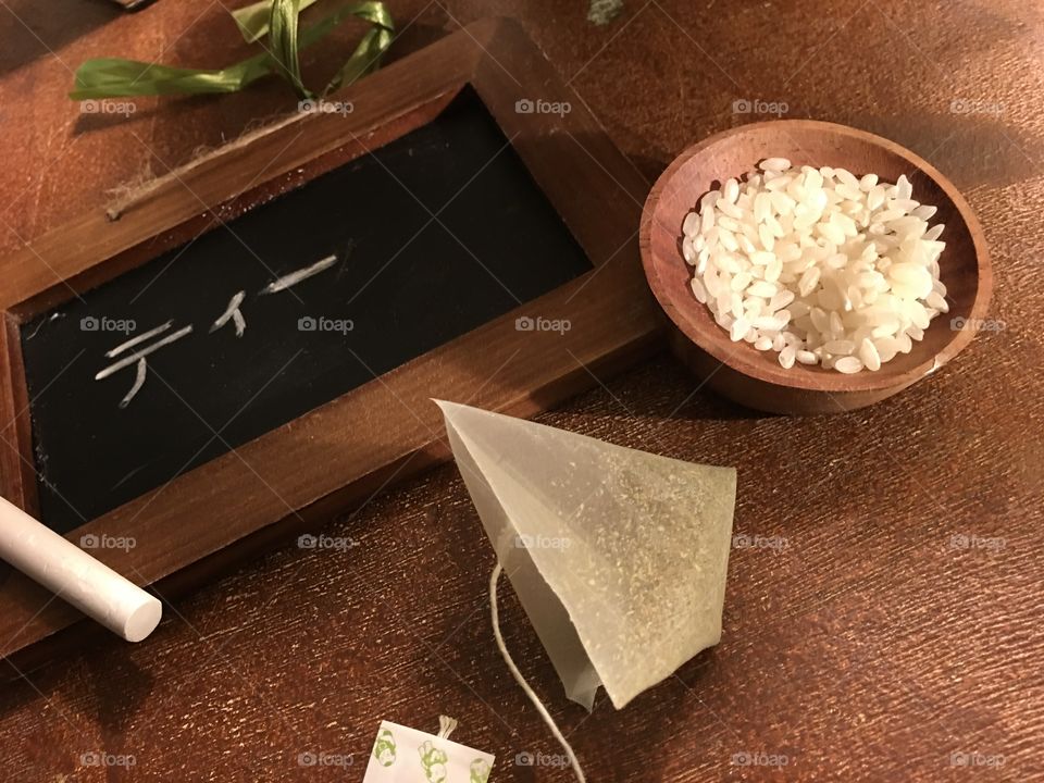 Green tea and Japanese rice with wooden blackboard with hand writing high angle view on wood table conceptual healthy choices background 