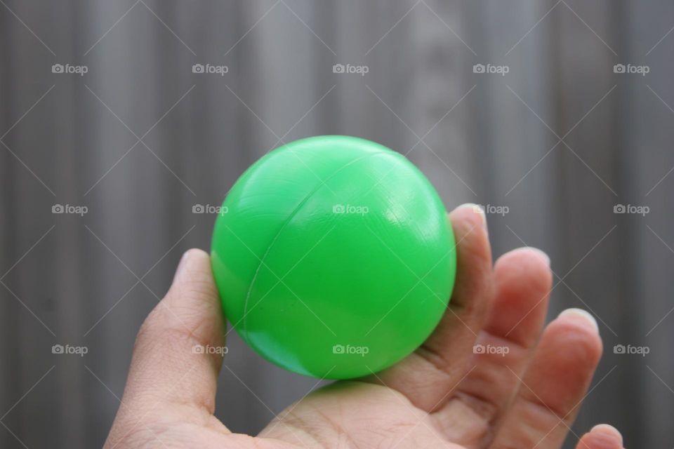 Holding a Green Plastic Ball, shallow depth of field