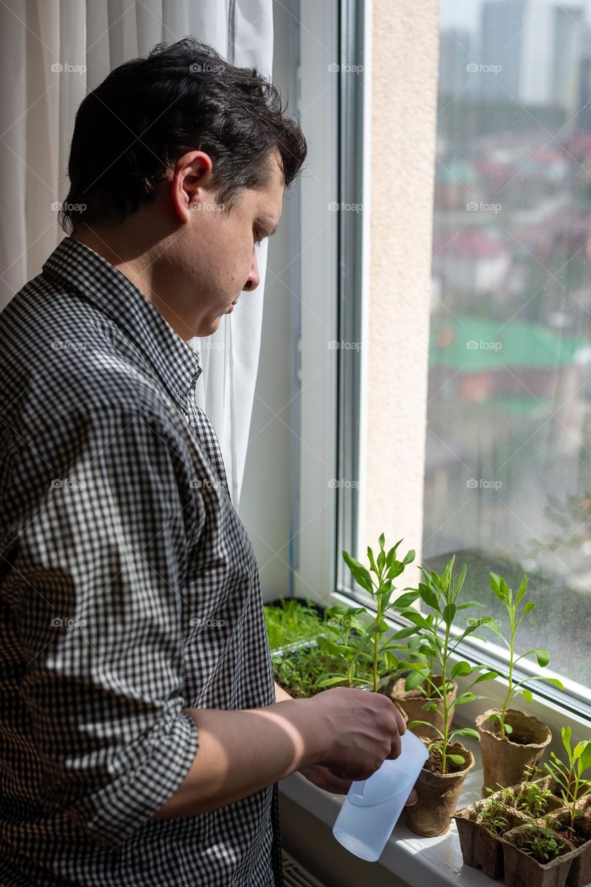 Man watering home selling on windows 